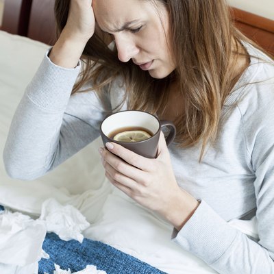 Woman with runny nose in bed