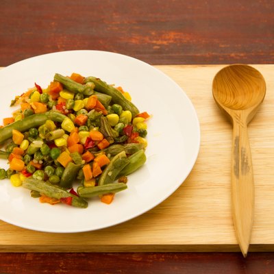 mixed vegetables on white plate on wooden background