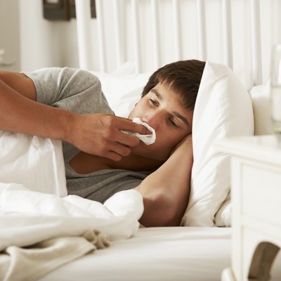 Sick Teenage Boy In Bed At Home