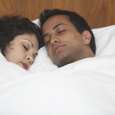 Middle Eastern couple sleeping in bed