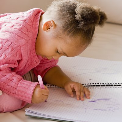 African girl drawing in notebook