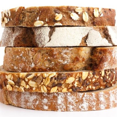 Mixed slices of health breads stacked. White surface.