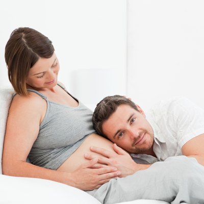 Husband listening to his wife's belly