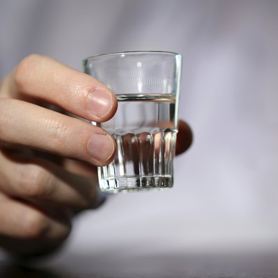 Man hand with glass of vodka , close up