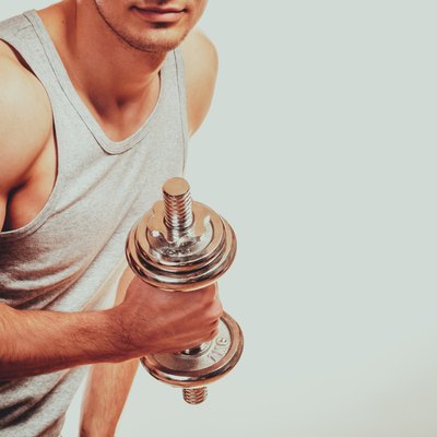 Strong fit man exercising with dumbbells.