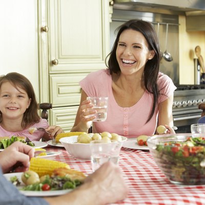 Family Eating Meal Together In Kitchen