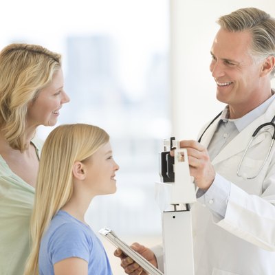 Doctor Examining Girl's Weight While Looking At Woman In Clinic