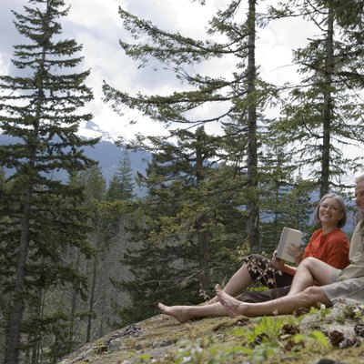 Senior couple having picnic in mountains, smiling