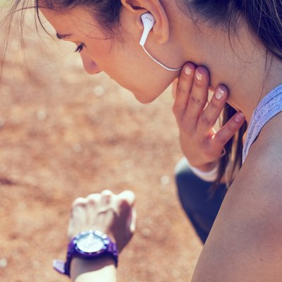 Young woman measuring heart rate after running