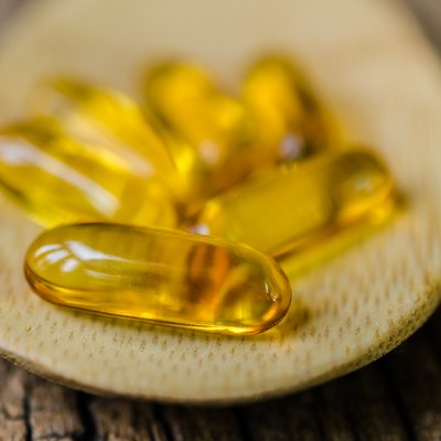 Fish oil on wooden spoon with wooden texture background
