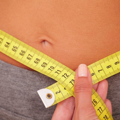 Sporty young girl getting waist measurement