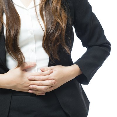 Young businesswoman having back and stomach pain