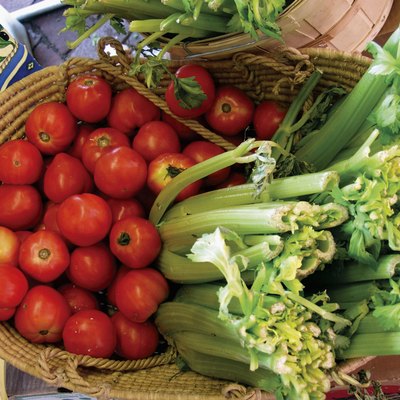 A basket of tomatoes and celery stalks