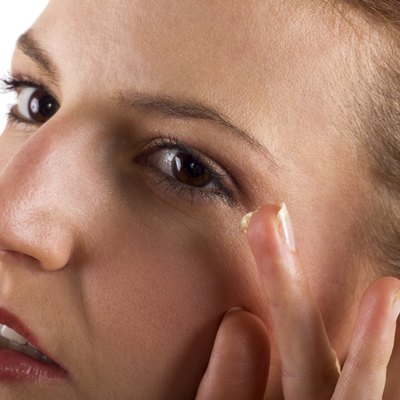 Woman applying anti aging cream ointments