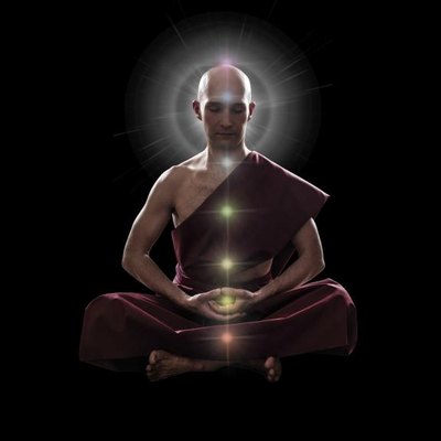 buddhist monk in meditation pose with colorful Chakras over black background