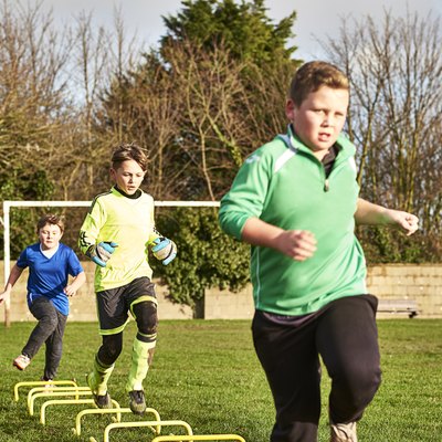 Children's football team running drills
