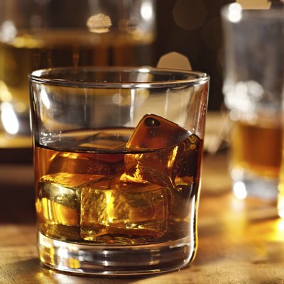 cocktail glass of whiskey on wood bar