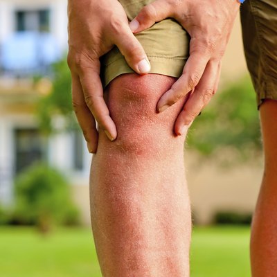 man holding hands sore knee