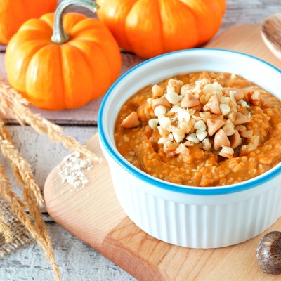 Table scene with bowl of autumn pumpkin oatmeal