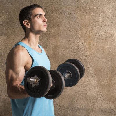 Young man beginning an "Arnold" dumbbell press.