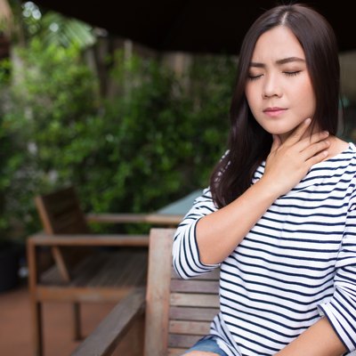 Woman has sore throat at coffee shop