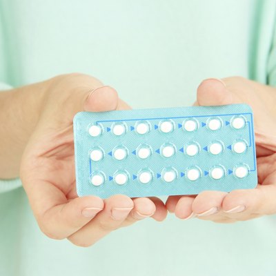Hormonal pills in female hands isolated on white