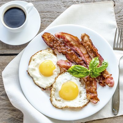Fried eggs with bacon on the wooden table