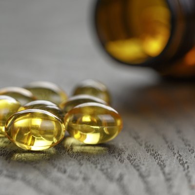 fish oil capsules with bottle on wooden table