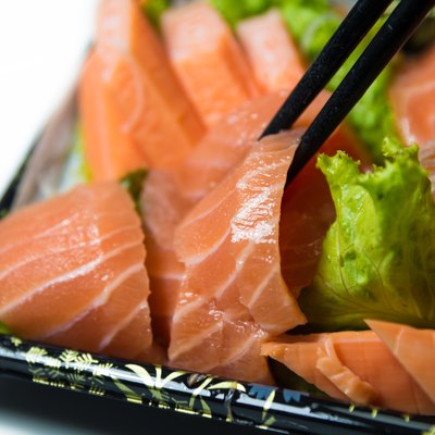 Chopstick grab a slice of Salmon Sashimi Japanese food closeup