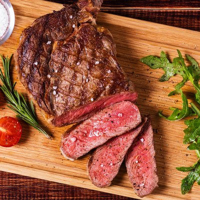 Ribeye steak with arugula and tomatoes.