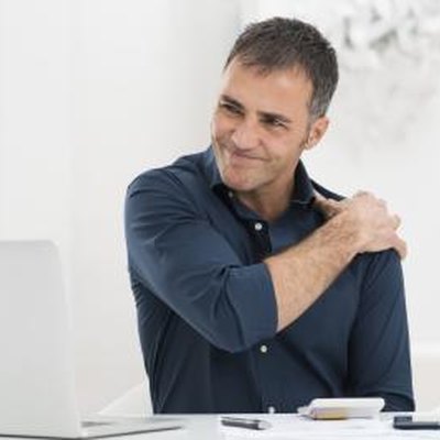 Portrait Of Mature Man At Work Suffering From Shoulder Pain
