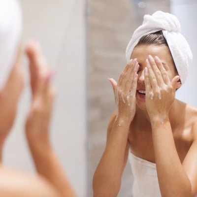Woman washing face in bathroom