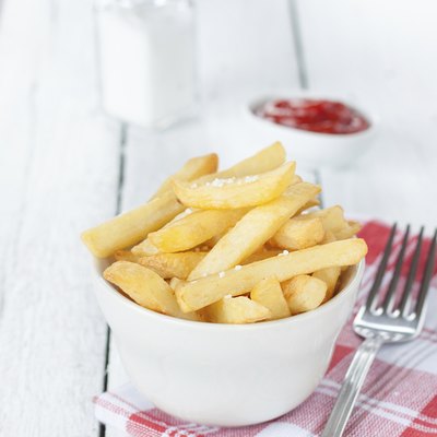 French fries in a white bowl on table