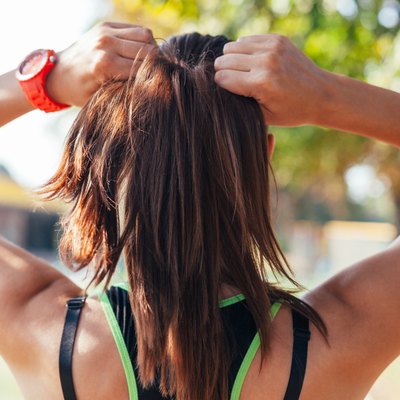 Young woman doing some warm-up exercises before running.