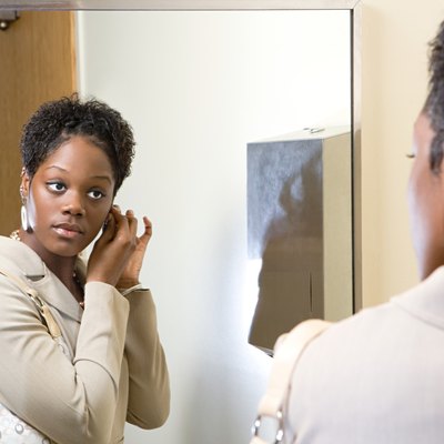 Woman putting on earrings