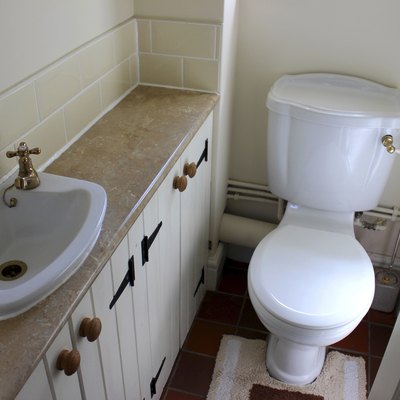 Image of country style cloakroom toilet, basin and storage cupboards