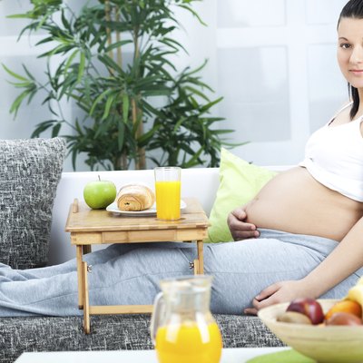 smiling young pregnant woman lying on the sofa