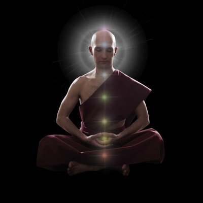 buddhist monk in meditation pose with colorful Chakras over black background
