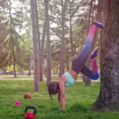 girl is having exercise on a tree , recreation in a park , having props lying on a grass