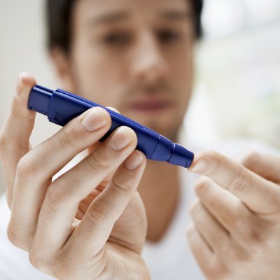 Man Using Lancelet On Finger In Bathroom