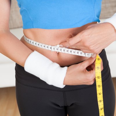 Happy woman measuring her waist