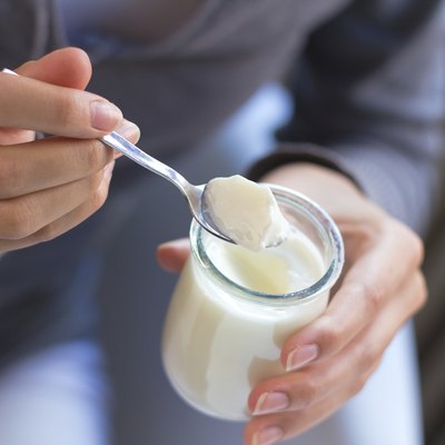 young beautiful woman eating yogurt at home
