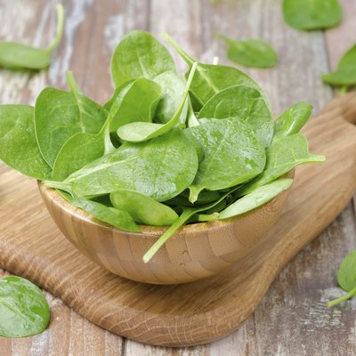 Fresh spinach in a wooden bowl, horizontal