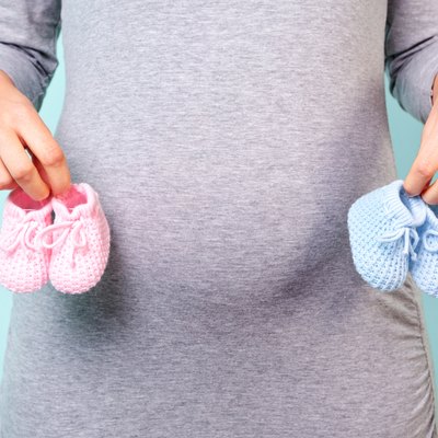 Pregnant woman holding baby booties