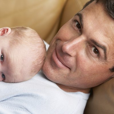 Portrait Of Father With Newborn Baby At Home