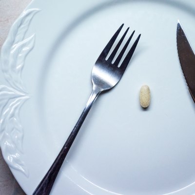 Single Pill/Tablet on a White Dinner Plate Overhead View