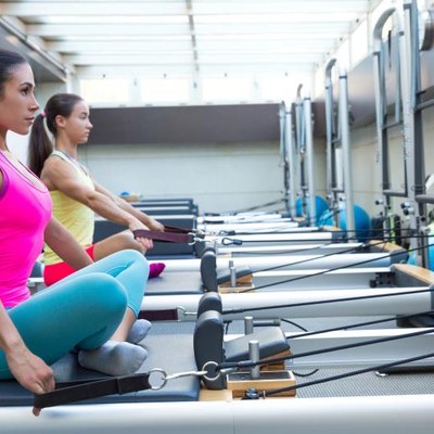 Pilates reformer workout exercises women at gym indoor