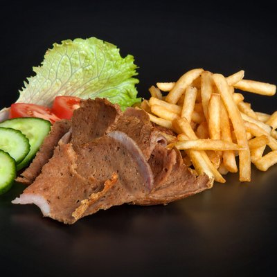 Kebab meat with fried potatoes and vegetables