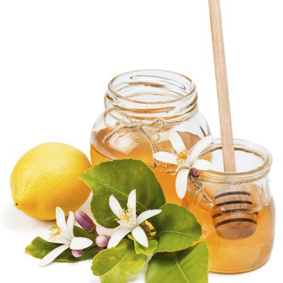 Glass jars of lemon honey with flowers