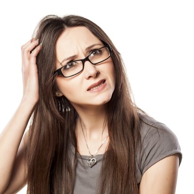 Young woman with questionable gesture scraping her hair